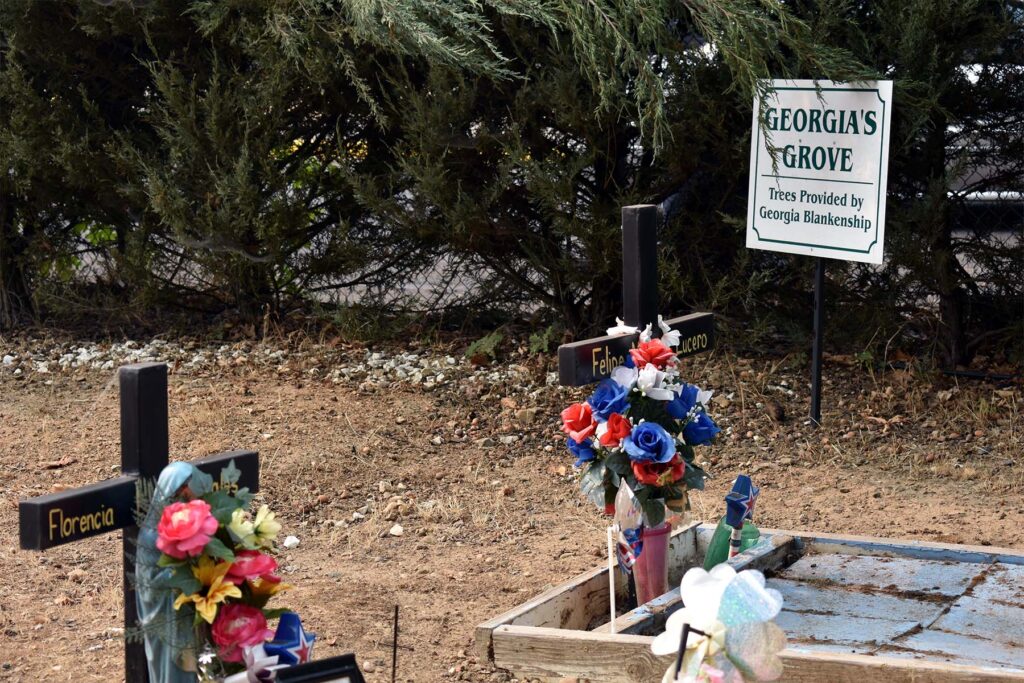 Two crosses on greave with flowers and a sign saying "Georgia's Grove, trees provided by Georgia Blankenship"