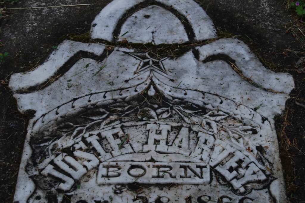 An engraved headstone lying on the ground